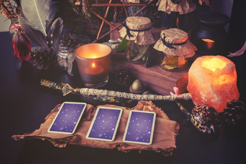 A Three-Card Spread Presented On A Decorated Table With Tea Lights Shells Wood Elements And So On