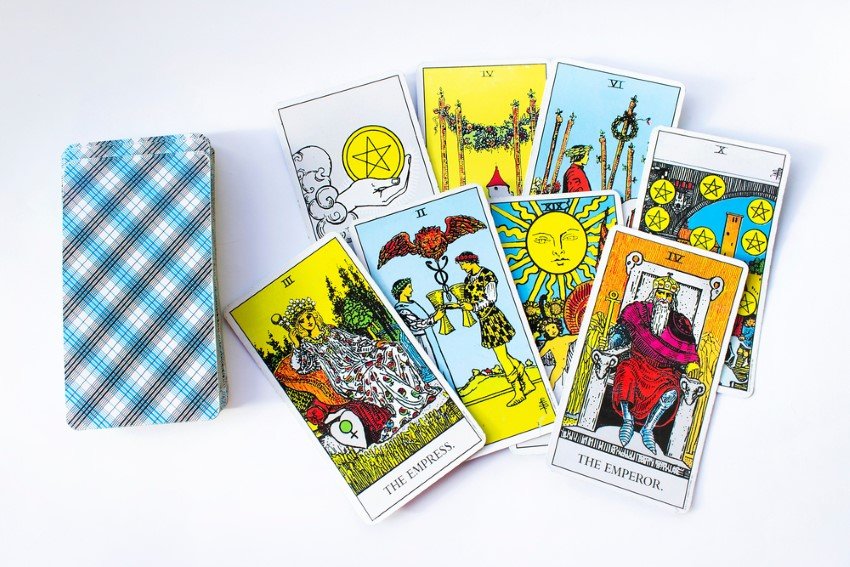 Neatly Stacked Pile Of Face-Down Rider-Waite Tarot Cards On The Left And Eight Cards On The Right Which Are Displayed With Both The Empress And Emperor Among Them
